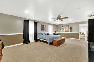 Carpeted bedroom featuring ceiling fan