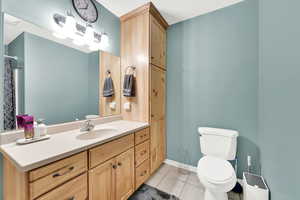 Bathroom featuring vanity, tile patterned flooring, and toilet