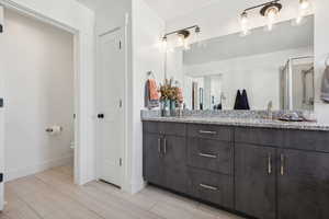 Bathroom with walk in shower, vanity, and toilet