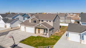 View of front of house featuring a front lawn, a garage, cooling unit, and a porch