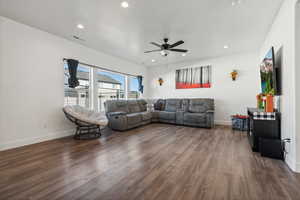 Living room featuring dark hardwood / wood-style floors and ceiling fan