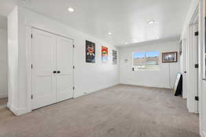 Unfurnished bedroom with a closet, a textured ceiling, and light colored carpet