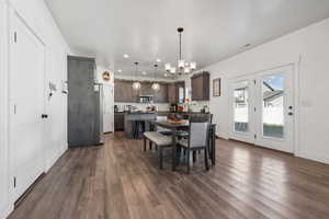 Dining room featuring dark hardwood / wood-style flooring, sink, and an inviting chandelier