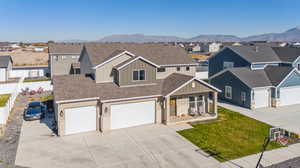 View of front of property featuring a mountain view, a garage, and a front lawn