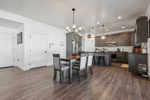 Dining space with dark wood-type flooring