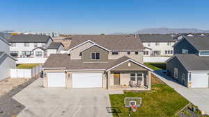 View of front of house with a mountain view, a garage, and a front yard