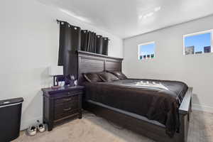 Bedroom featuring a textured ceiling and light carpet