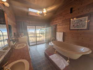 Bathroom with wooden ceiling, a tub, wooden walls, and vaulted ceiling