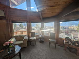 Sunroom / solarium with a mountain view, wood ceiling, and lofted ceiling