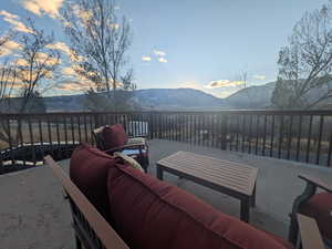 Patio terrace at dusk with a deck with mountain view and an outdoor living space