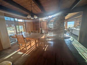 Unfurnished dining area featuring a chandelier, a wealth of natural light, hardwood / wood-style floors, and wood ceiling