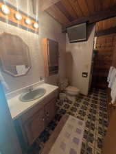 Bathroom with wooden ceiling, vanity, and toilet