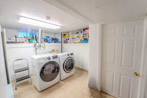 Laundry room featuring light tile patterned flooring and washer and dryer