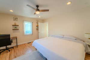 Bedroom with ceiling fan and hardwood / wood-style floors