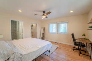 Bedroom with ceiling fan, a spacious closet, ensuite bathroom, and light hardwood / wood-style floors