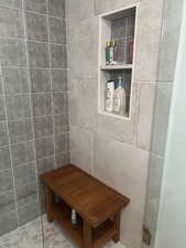 Bathroom with a shower, tile walls, and tile patterned floors