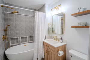 Full bathroom with vanity, toilet, and plus walk in shower