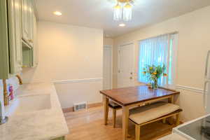 Dining area with light hardwood / wood-style floors and sink