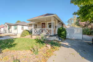 Bungalow featuring a porch and a front lawn