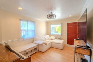 Living area featuring wood-type flooring and ornamental molding