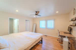 Bedroom featuring light wood-type flooring, ceiling fan, and connected bathroom