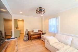 Living room featuring wood-type flooring and crown molding