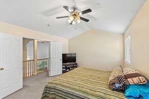 Master bedroom featuring vaulted ceiling and ceiling fan