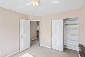 Unfurnished bedroom featuring light carpet, and a closet