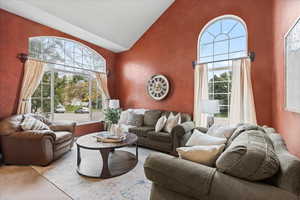 Living room featuring high vaulted ceiling