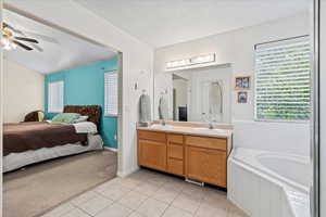 Master bathroom featuring tile patterned flooring, vanity, a textured ceiling, and ceiling fan