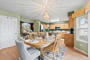 Dining area featuring a wealth of natural light, light hardwood / wood-style floors, and an inviting chandelier