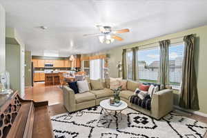 Family room with ceiling fan, a textured ceiling, and light wood-type flooring