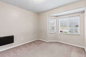 Bedroom room with a textured ceiling and light colored carpet