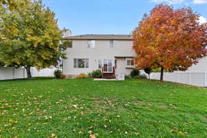 Rear view of house featuring a yard