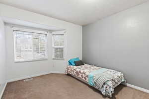 Carpeted bedroom with a textured ceiling