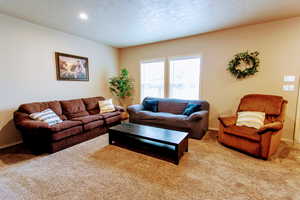 Living room with a textured ceiling and light carpet