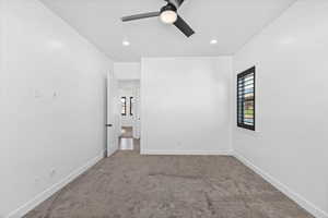 Carpeted spare room featuring ceiling fan