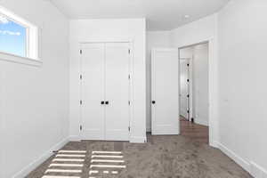 Unfurnished bedroom with carpet and a closet