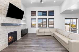 Unfurnished living room with a stone fireplace and wood-type flooring