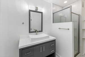 Bathroom featuring vanity and a shower with door