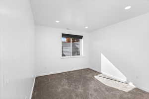 Spare room featuring dark colored carpet