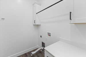 Clothes washing area featuring cabinets, hardwood / wood-style flooring, hookup for a washing machine, and hookup for an electric dryer