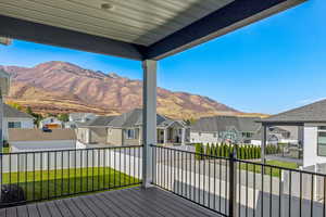 Wooden deck featuring a mountain view and a yard