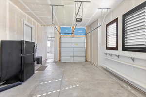 Garage with black fridge and a garage door opener