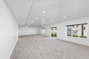 Unfurnished room featuring light colored carpet and plenty of natural light