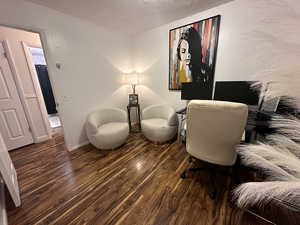 Office space with dark hardwood / wood-style flooring and a textured ceiling