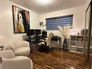 Office featuring dark wood-type flooring and a textured ceiling