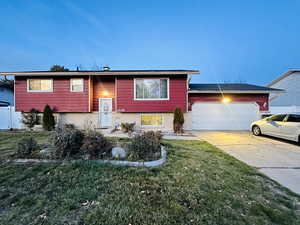 Split foyer home featuring a front lawn and a garage