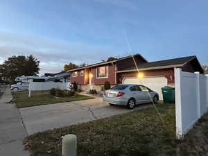 View of front of house with a garage and a yard