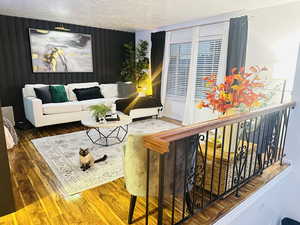 Living room with dark wood-type flooring and a textured ceiling